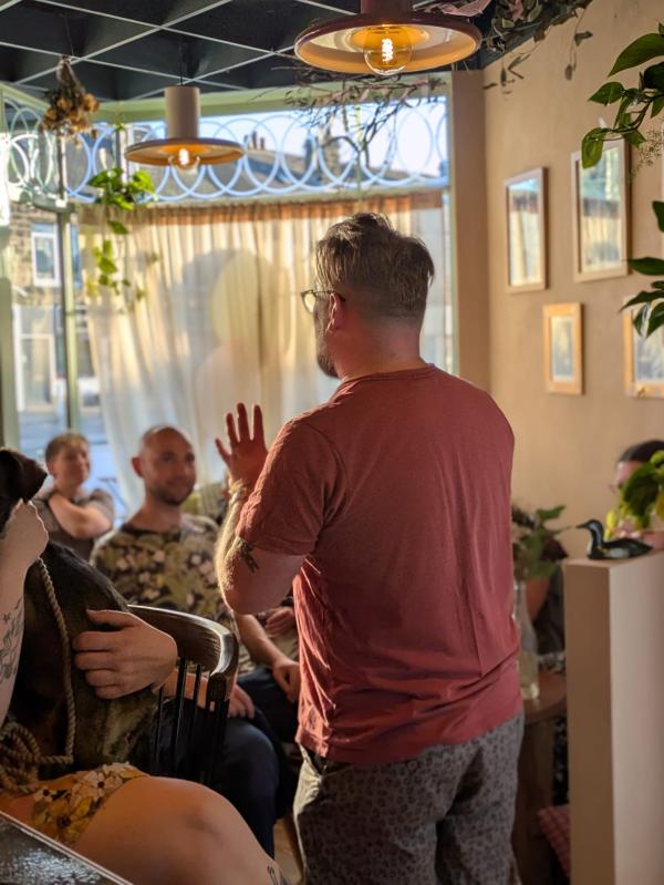 image shows Brave Words Artistic Director Chris Singleton speaking to a crowd of people at a storytelling event