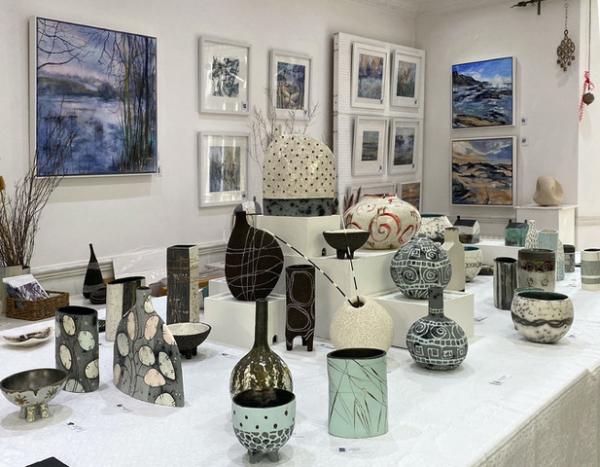 Photo taken at last year’s Open Studios showing a central display of ceramics and artworks around the walls. 