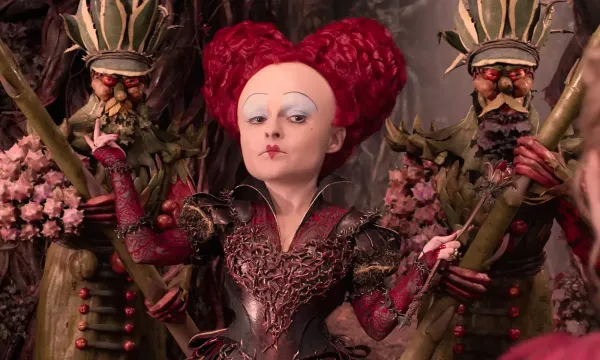 The Queen of Hearts faces the camera with two guards behind her.