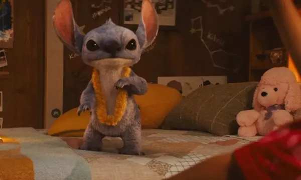 Stitch stands on abed looking alert.