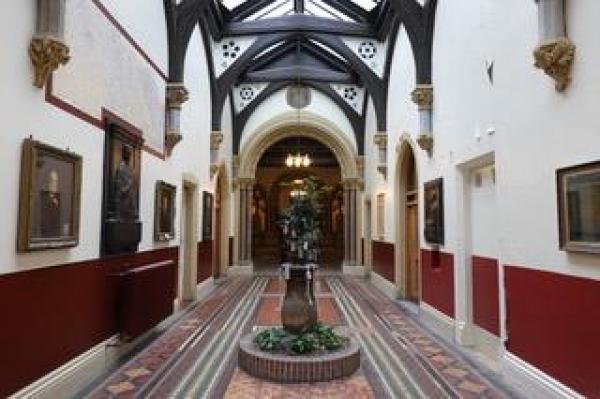 Inside of church building. White walls, statue structure in the middle of corridor