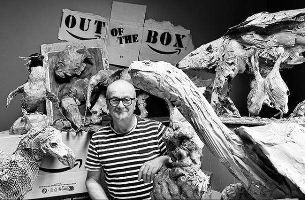 Sculptor surrounded by his various pieces, made from different materials.