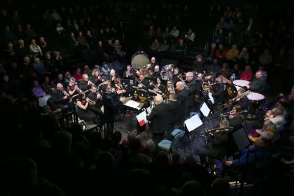 A brass band performing on a stage. 