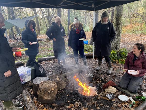 Photograph of women at a campfire