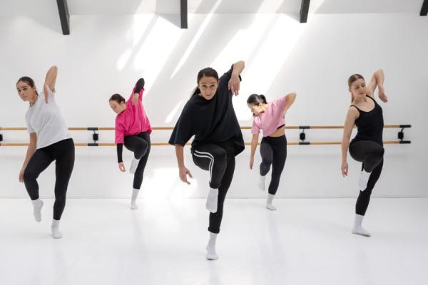 Five dancers with a knee and elbow raised