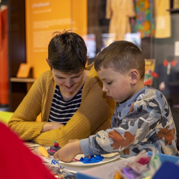 A woman and a child making something crafty in the M&S Archive exhibition