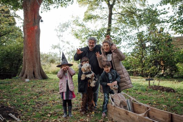 A family pose next to skeleton from the Scarytales trail.