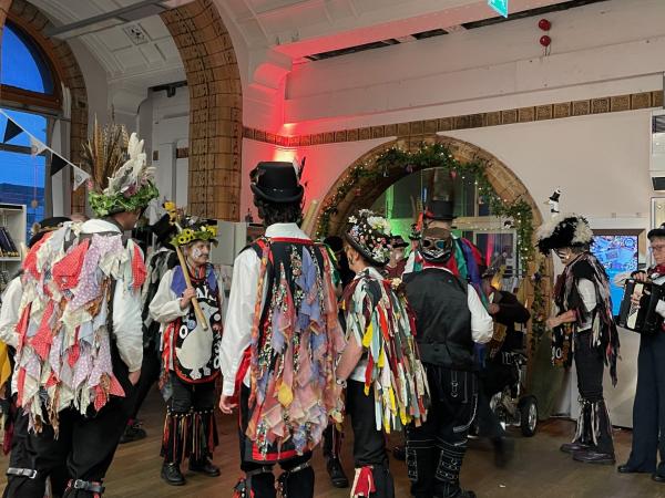 Morris Dancers in black and white clothes decorated with colourful rags