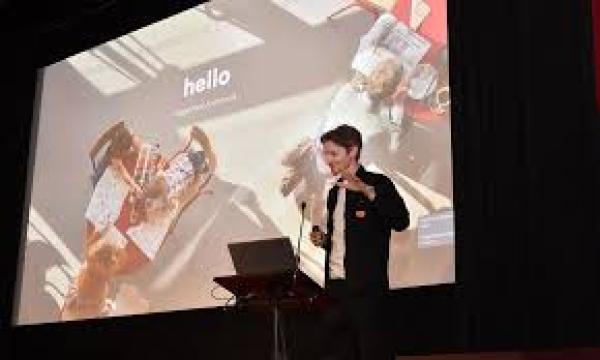 Mark Johnston giving a talk in front of a lecturn, laptop and big screen