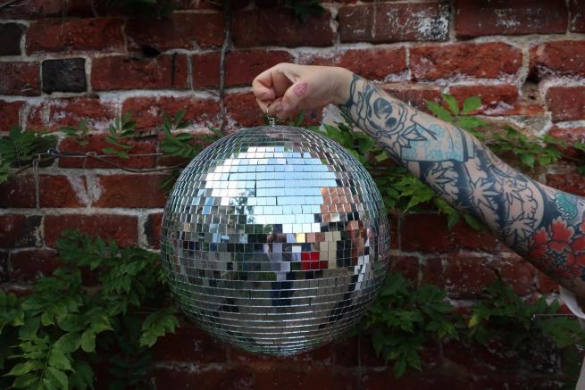 an arm holding a glitter ball