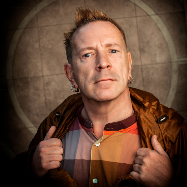 John Lydon stares into the camera against a beige backdrop.