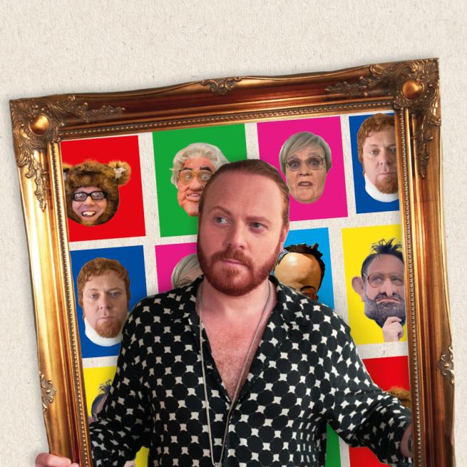 Leigh Francis is standing in front of a framed picture of his many characters.