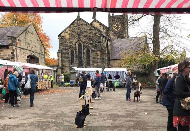 a view from the chocolate stall accross the outside market area with st john's church as a backdrop