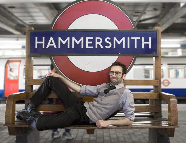 MC Hammersmith in front of the London Underground sign for Hammersmith