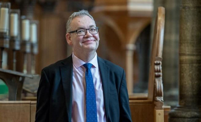Roger Sayer stood in a church looking into the distance. 