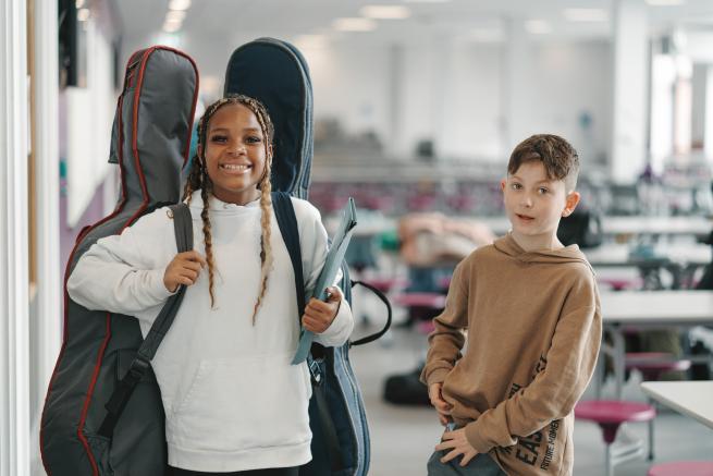 Two young cellists smiling 