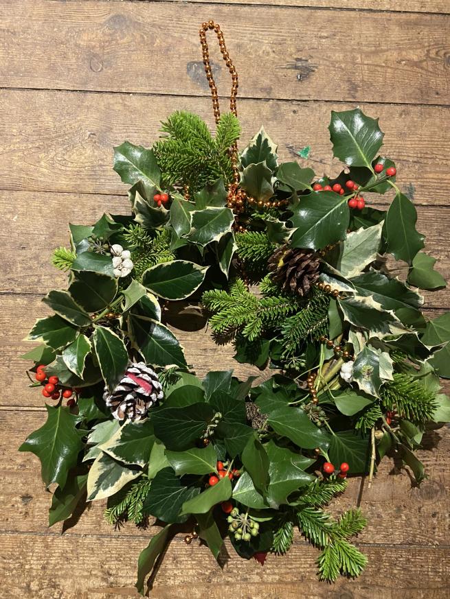 A traditional wreath in front of a wooden backdrop