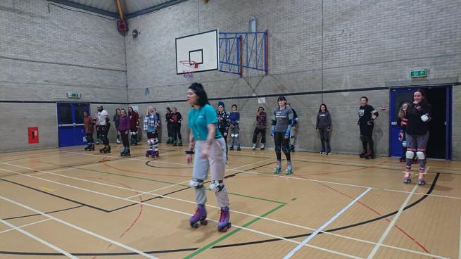 A skate coach teaches a group of skaters
