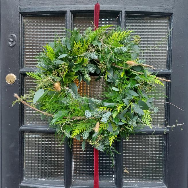 A handmade foliage wreath hung on a door
