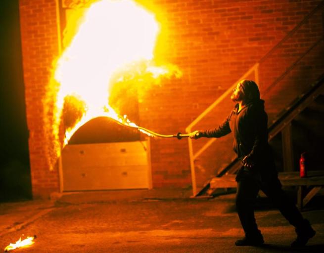 A Yorkshire Circus Performer creating a fireball effect using a lit fire whip 