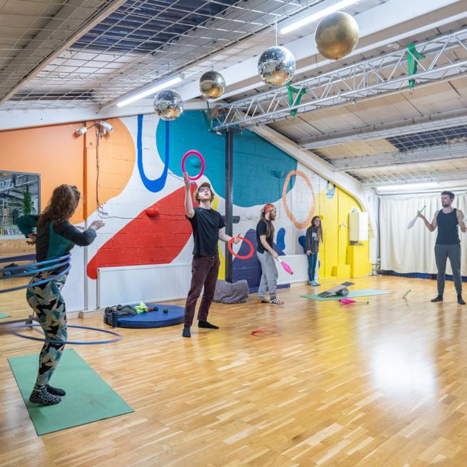 Group of Circus practitioners training in our dance studio. Examples of hula-hooping, juggling rings and clubs