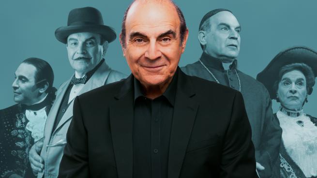 A person smiling, in a black suit. In the background, the same person playing different characters.
