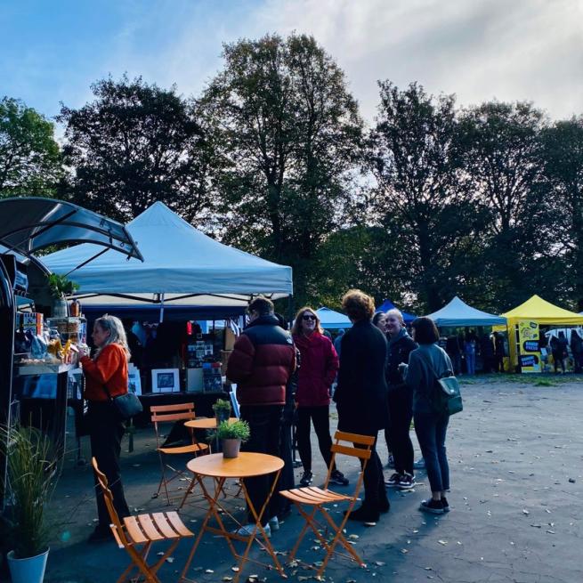 A group of people waiting in line at The Moor Market stalls.