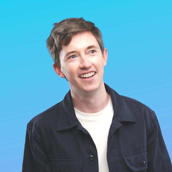 Jake smiling with a blue backround