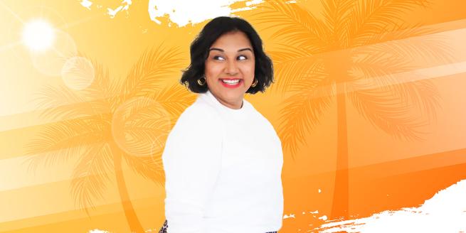 Sukh smiling in front of an orange background 