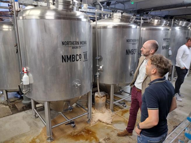 Tour guests looking at an in-use fermenter in the brew house at Northern Monk Refectory