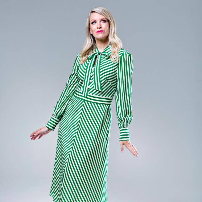 Rachel Parris in a green striped dress looking off to the side
