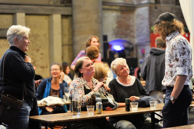 Image shows poets and audience members chatting between events.