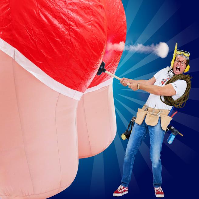 A person wearing blue jeans and a white t-shirt holding a plunger against a giant inflatable bottom.