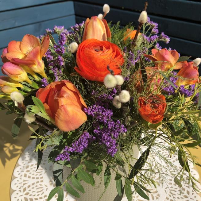 A centrepiece using orange and purple flowers