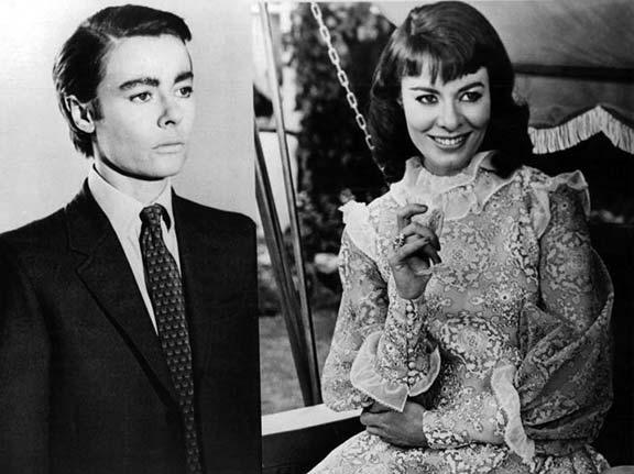 The actress Anne Heywood in a before and after style transition style image of the trans character she portrays in the film. To the lefthand side is the before image where she has short, slicked back hair and is wearing a suit. The right hand side is the after image of her in a floral dress with lots of frills and gathering. both are in black and white.