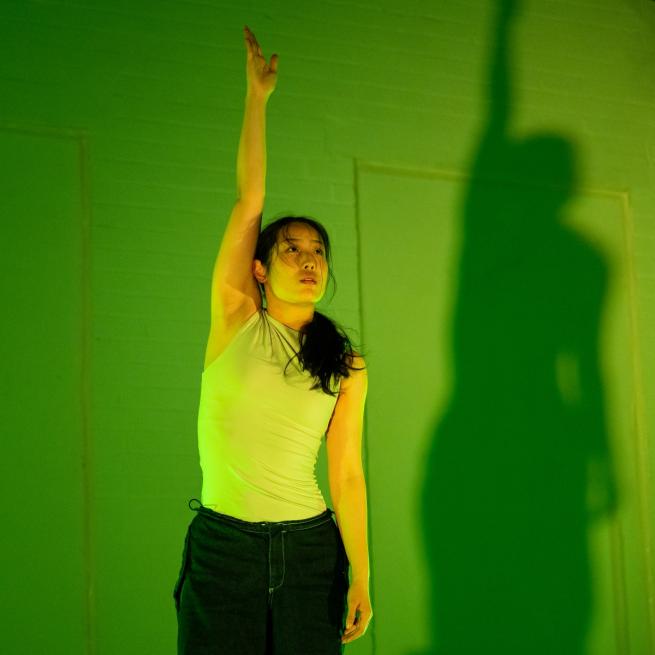 Female dancer with arm reaching upwards