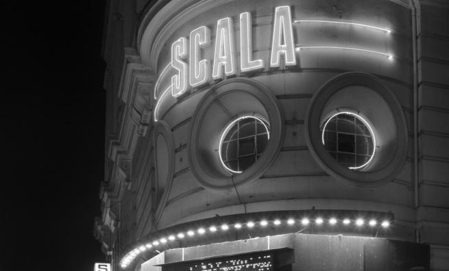 Black and White image of Cinema exterior with large flourescent sign saying SCALA