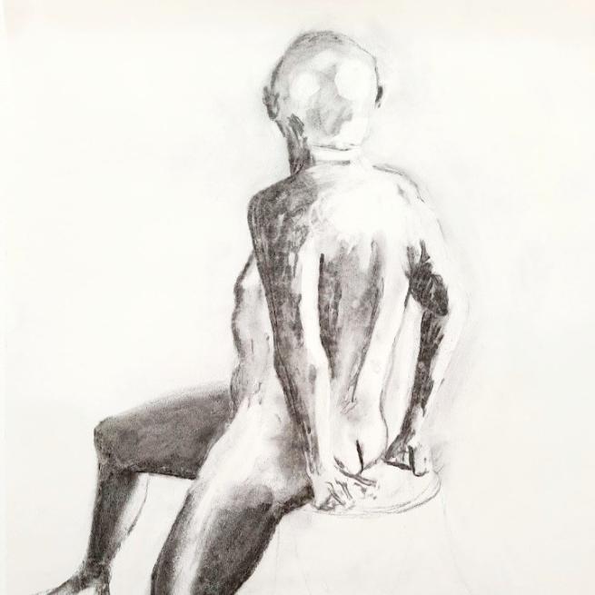 A life drawing in charcoal of a man sat down with his back facing us