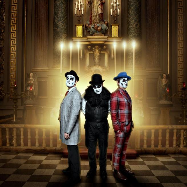 The three Tiger Lillies members stood at the alter of a church wearing fedoras with their faces painted white.