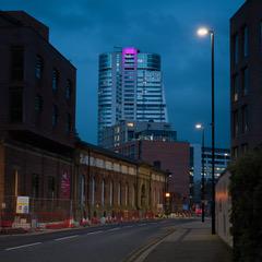 picture of the Bridgewater Place building in the distance ,highlighted with a pink neon light .