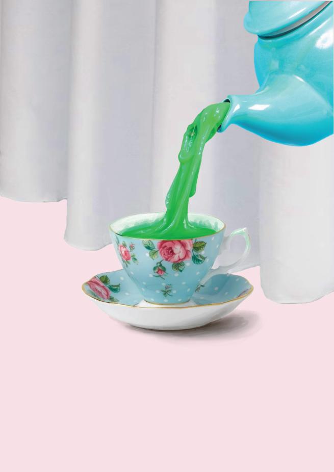 A blue teapot pouring green, sludge like, water into a fine china teacup
