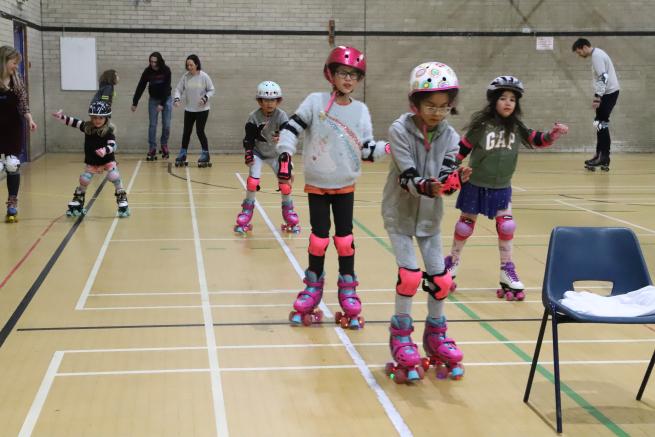 Children roller skating in a sports hall 