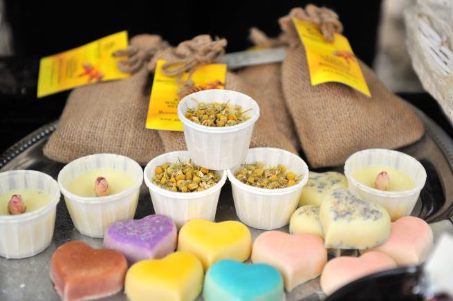 A table with heart shaped wax melts, candles in small pots and bags of pot pourri.