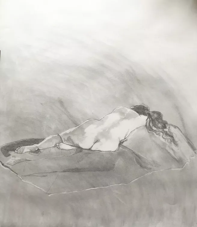 A pencil and charcoal drawing of the back view of a female life model in a reclining position 