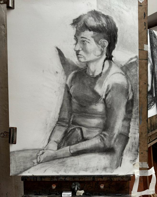 A charcoal drawing of a girl seated.