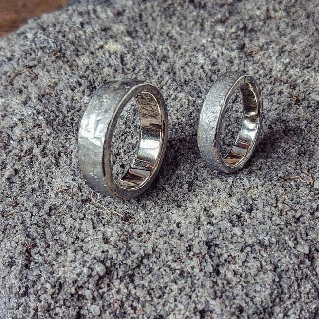 Two silver rings against a grey background