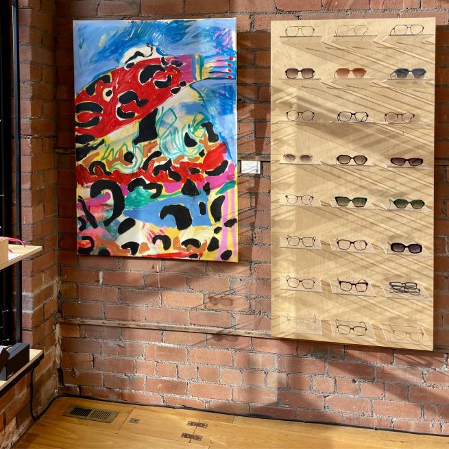 A colourful painting on a brick wall inside an optician's store