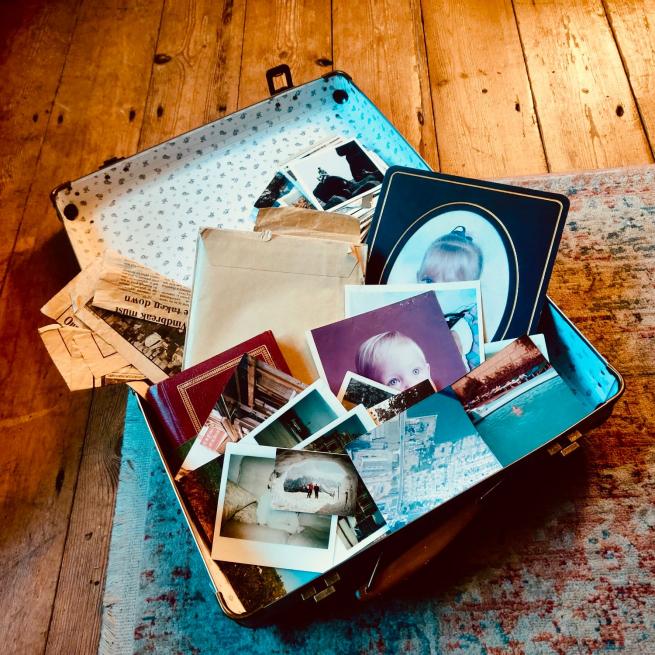An open suitcase displays a number of old photographs