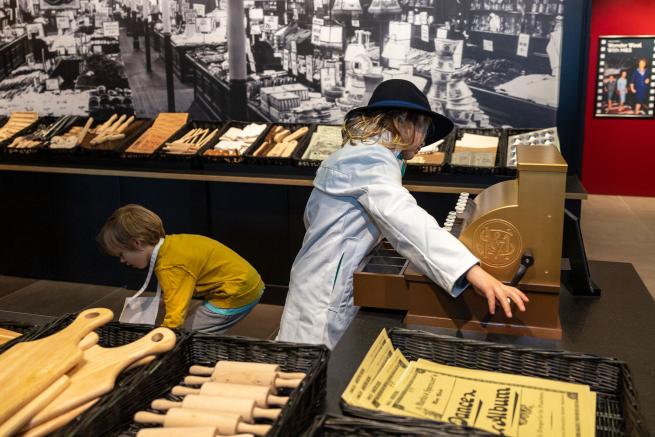 A colour photo of two children playing in a replica shop