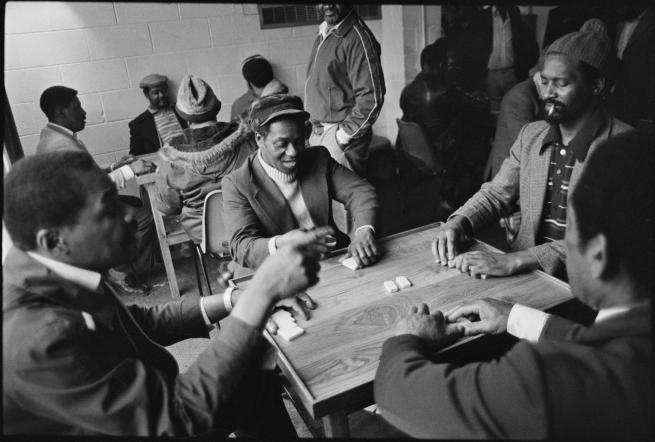 A group of men playing dominos at Leeds West Indian Centre, Laycock Place. Apr 1983. © Historic England Archive.